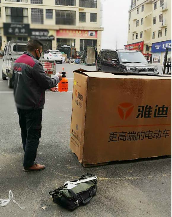 日日順物流服務兵對電動車外包裝進行消毒處理